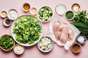 Romaine, chicken, snap peas, cucumbers, chives, dill, parsley, chèvre and spices in prep bowls