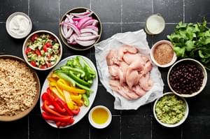 chicken, peppers, onions, rice, beans, taco seasoning, guac, cilantro, lime juice and sour cream in prep bowls