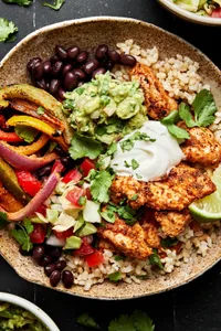chicken fajita burrito bowl with  beans, rice, peppers, onions and topped with guac and sour cream