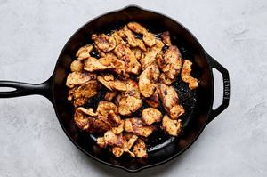chicken marinated in pineapple, lime juice, spices, jalapeño, Worcestershire, cilantro & onion being cooked in a skillet