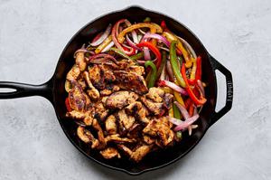 fajita chicken, peppers and onions in a skillet