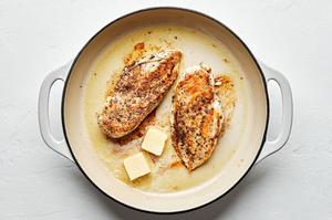 chicken breast seasoned with salt, pepper and italian seasoning being cooked in a skillet with olive oil and butter