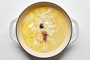butter, garlic, garlic powder, nutmeg, salt, and pepper being cooked in a skillet to make homemade alfredo sauce
