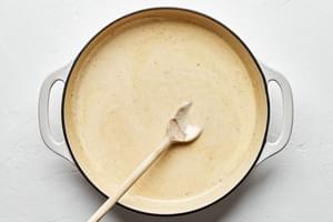 homemade alfredo sauce in a pan made with parmesan, cream, butter, garlic, garlic powder, nutmeg, salt, and pepper