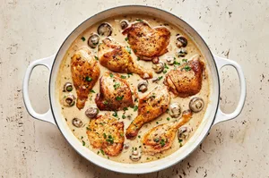 chicken cooking in broth, mushrooms, onion, garlic, thyme, bay leaves, nutmeg, butter, flour cooking in a braiser
