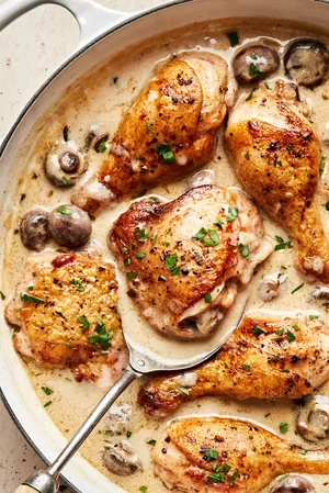 chicken fricassee made with mushrooms, onion, garlic, thyme, bay leaves and nutmeg in a pot
