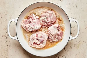 chicken seasoned with salt and pepper cooked in melted butter in a skillet