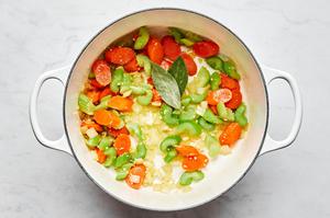 onion, celery and carrots being cooked in olive oil in a skillet