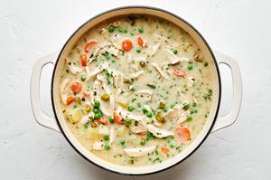 a pot of homemade chicken pot pie soup with potatoes, chicken, carrots, celery, peas and onions