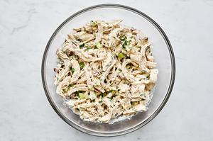 chicken salad in a bowl made with mayo, dijon, spices, celery, pecans, parsley, lemon zest & lemon juice