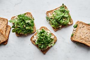 chicken salad sandwiches being made with chicken salad on bread topped with arugula