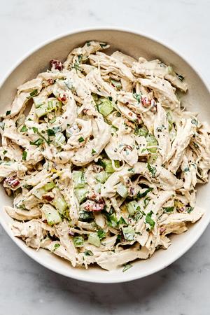 chicken salad in a bowl made with mayo, dijon, spices, celery, pecans, parsley, lemon zest & lemon juice