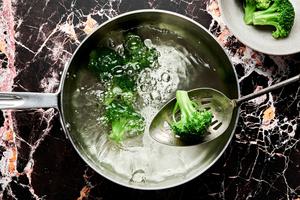 broccoli being blanched in a large pot of hot water