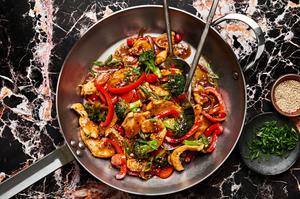 chicken stir fry in a pan made with broccoli, onion, bell pepper, carrots and homemade stir fry sauce