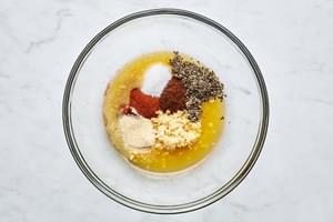 orange juice, lime juice, garlic, chili powder, onion powder, paprika, salt, and pepper in a bowl