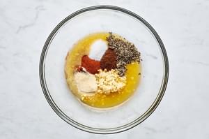 orange juice, lime juice, garlic, chili powder, onion powder, paprika, salt, and pepper in a bowl