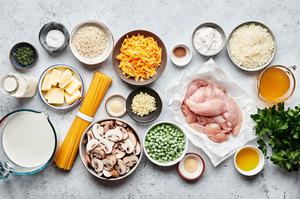spaghetti, chicken, butter, milk, cream, Parmesan, cheddar, peas, mushrooms and spices in prep bowls