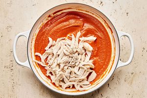 shredded chicken being tossed with homemake smoky tinga  sauce to make flavorful chicken tinga tacos