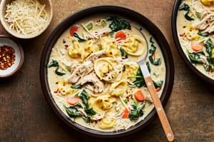 a bowl of chicken tortellini soup made with cream, parmesan, spinach, pepper, salt, paprika and italian seasoning