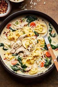 a bowl of chicken tortellini soup made with cream, parmesan, spinach, pepper, salt, paprika and italian seasoning