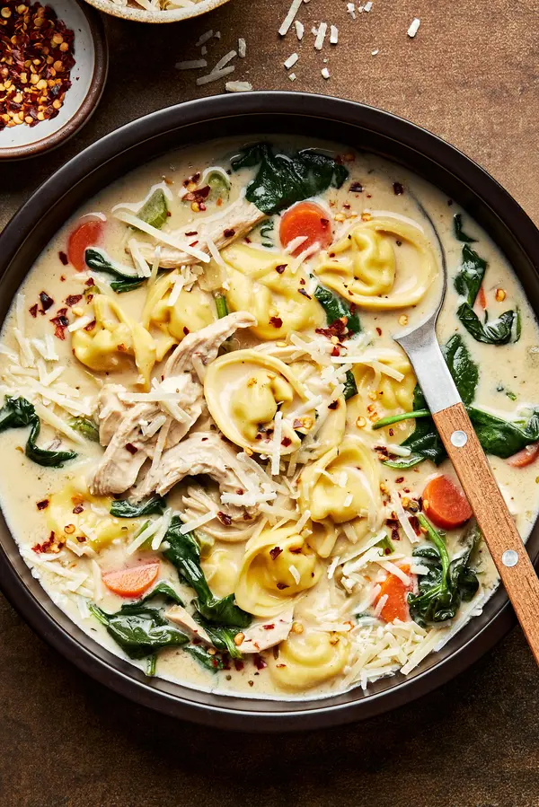 a bowl of chicken tortellini soup made with cream, parmesan, spinach, pepper, salt, paprika and italian seasoning