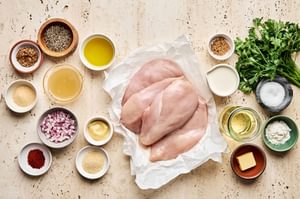 ingredients laid out to make chicken with mustard cream sauce including spices, dijon, whole grain mustard, cream and butter