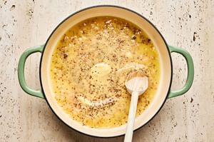 Creamy mustard sauce cooking in a skillet to be used as a finishing touch for baked chicken