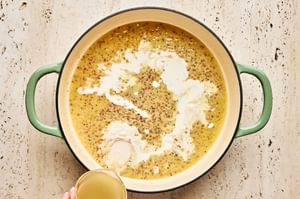 a butter and flour roux added to a skillet of mustard cream sauce to thicken it