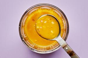 turmeric vinaigrette in a jar made with olive oil, apple cider vinegar, shallot, turmeric, mustard, honey and salt.