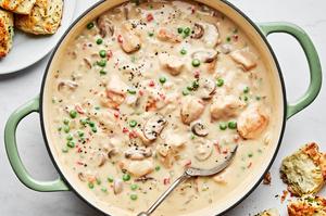 a skillet of Chicken à la King made with chicken, peas, mushrooms, pimentos, onions and spices