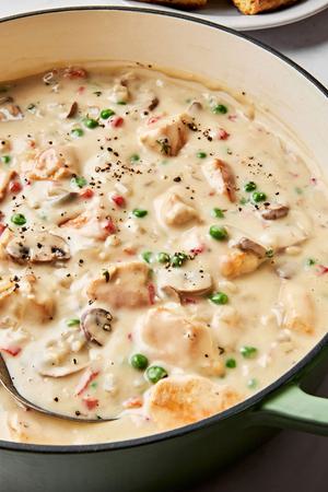 a skillet of Chicken à la King made with chicken, peas, mushrooms, pimentos, onions and spices