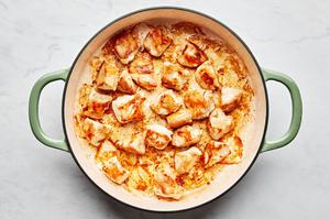 cut up chicken breast seasoned with salt being cooked in olive oil in a skillet