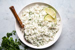 homemade cilantro lime rice in a bowl with a wooden spoon