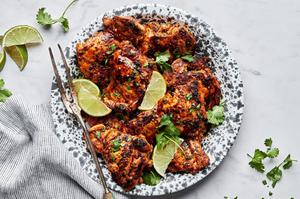 cilantro lime chicken thighs on a serving platter garnished with cilantro and lime wedges