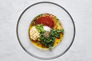 olive oil, garlic, honey, lime zest, lime juice, cilantro, chili powder, salt, and pepper. in a glass bowl