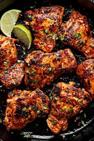 cilantro lime chicken thighs being cooked in a cast iron skillet