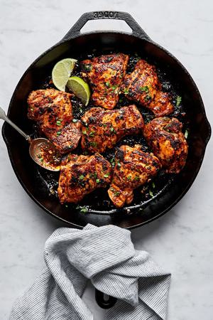 cilantro lime chicken thighs being cooked in a cast iron skillet
