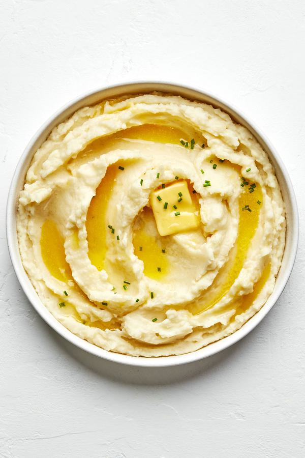 a bowl of homemade classic mashed potatoes made with butter, milk, salt & garlic powder topped with a pat of melting butter