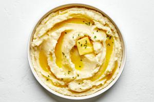 a bowl of homemade classic mashed potatoes made with butter, milk, salt & garlic powder topped with a pat of melting butter