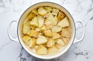 cut up gold potatoes being boiled in a pot of hot water
