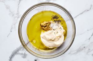 mayo, olive oil, stone ground mustard, pick juice, salt and pepper being combined in a bowl