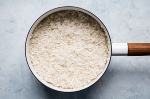 a sauce pan full of creamy coconut rice made with water, coconut milk, sugar and salt