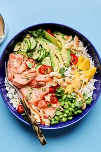 Coconut Rice Salmon Bowl with avocado, mango, cucumber, all drizzled with a coconut milk dressing