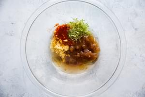 asian inspired dressing ingredients in a bowl brown sugar, lime zest, lime juice, ginger, garlic, chili sauce