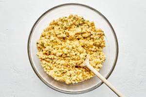 corn, flour, cornmeal, sugar, baking powder, salt, cayenne, and garlic powder being stirred together in a bowl