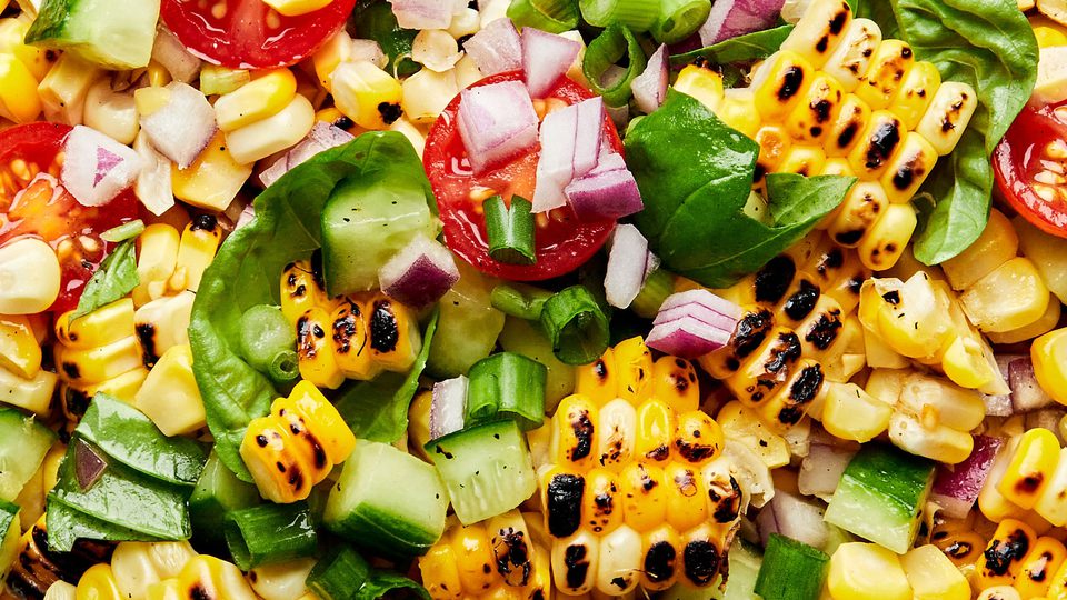 Corn salad with cherry tomatoes, cucumber, basil and honey lime dressing