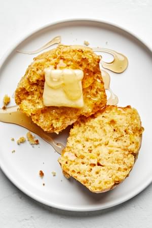 A single cornbread muffin, cut in half, buttered, and drizzled with jalapeño-infused honey
