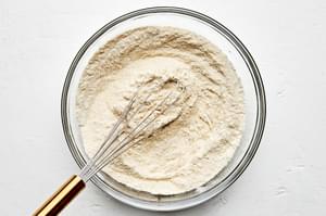 Flour, cornmeal, sugar, baking powder, baking soda, and salt, whisked together in a bowl