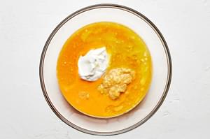 An un-mixed bowl of creamed corn, eggs, butter, and sour cream