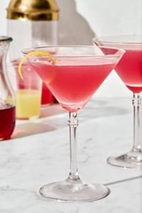 A homemade Cosmopolitan cocktail with a twist of lemon, served in a classic martini glass.